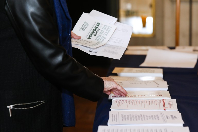 A woman picks up ballot papers as she prepares to vote during French Senate elections at the Hotel de Ville of Paris on September 24, 2017. Half of the seats in the upper house are up for grabs in the indirect election, in which only elected lawmakers -- parliamentarians, mayors, local councillors -- can vote.