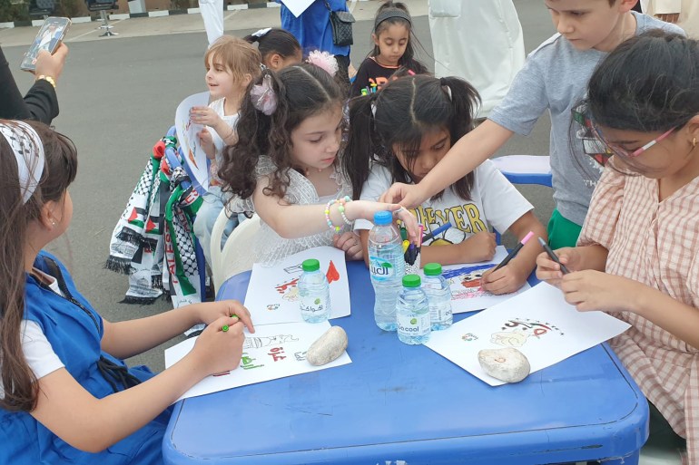 اطفال يقومون بوضع اسماء مدن فلسطين على الخريطة (الجزيرة)